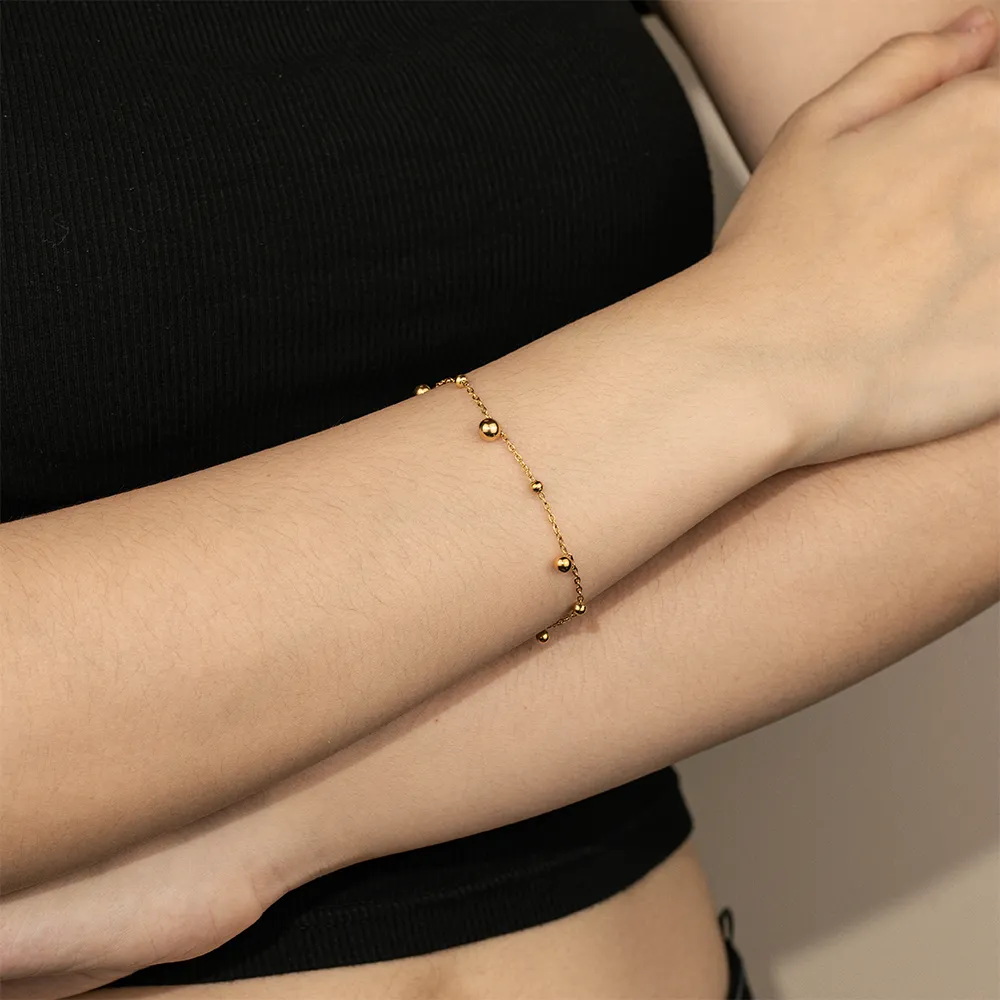Female model wearing 18K gold-plated bead bracelet to showcase fit for businesses