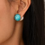 Female model wearing stainless steel enamel imitation pearl earrings to showcase fit for emerging designers