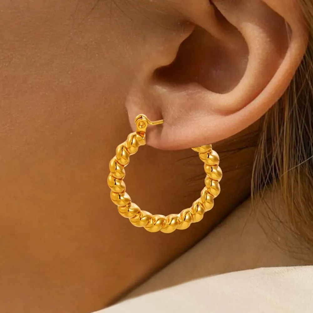 Female model wearing 2.4cmx2.4cm stainless steel twisted hoop earrings to showcase fit for brands