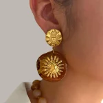 Female model wearing pineapple Resin earrings to showcase size and fit for Jewelry Direct Source