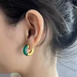 Female model wearing hoop Resin earrings to showcase size and fit for Jewelry Direct Source