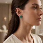 A profile view of a woman wearing a vibrant green gemstone emerald-cut earring set in a turquoise candy color resin base. This fully customizable resin stud earring highlights premium craftsmanship, ideal for B2B jewelry suppliers seeking unique fashion accessories.