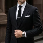 Male model wearing black enamel pattern logo tie clip to showcase fit for Online Boutiques