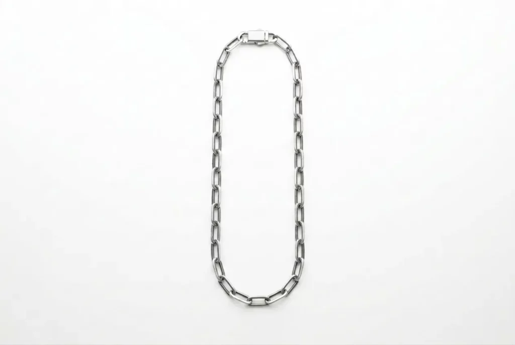 Custom polished paperclip chain with rectangular clasp, laid flat in elongated oval on white background – open elongated links with silver luster. B2B ready for OEM/ODM orders, ideal as modern base chain for charm bracelets.