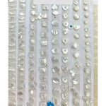 A variety of custom seashell carving and mother-of-pearl shapes for jewelry making, featuring hearts, flowers, clouds, and geometric inlays in natural white shell finish by Dongguan Haosen Metal Jewelry.