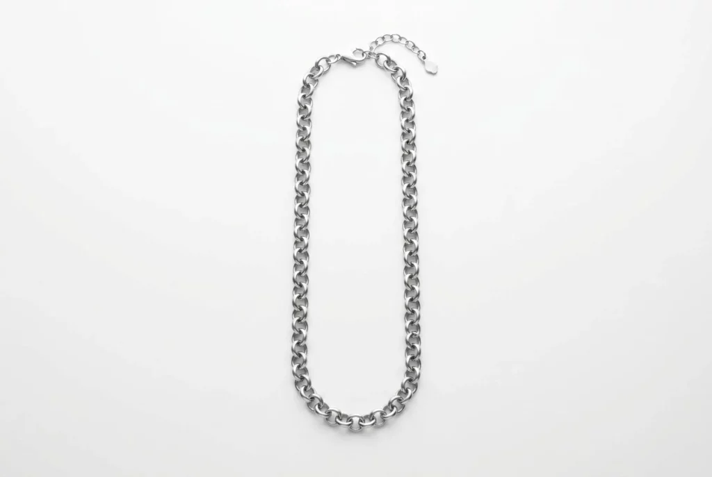 Custom polished rolo chain with lobster clasp and extension chain, laid flat in elongated oval on white background – uniform interlocking round links with soft silver luster. B2B ready for OEM/ODM orders, ideal as base chain for charm bracelets or standalone necklaces.