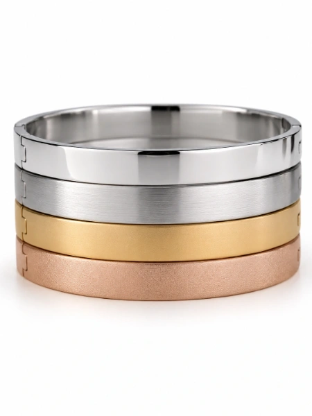 Custom stainless steel bangle finish and plating options showing stacked bracelets with polished, brushed, matte and textured surfaces in silver, gold and rose gold tones