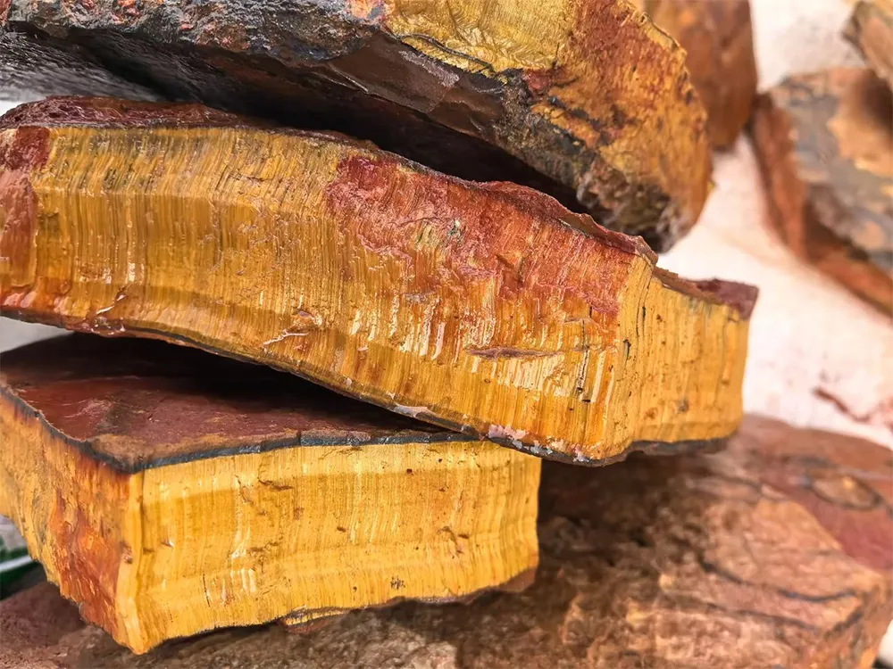 Raw natural tiger's eye stone slabs, rough gemstone material with golden fibrous texture, unpolished mineral blocks