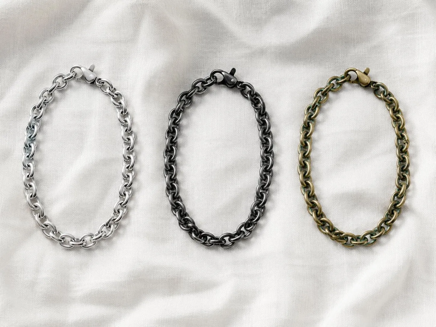 Three jewelry chains comparing 316L stainless steel, sterling silver, and brass to show which metals tarnish over time.