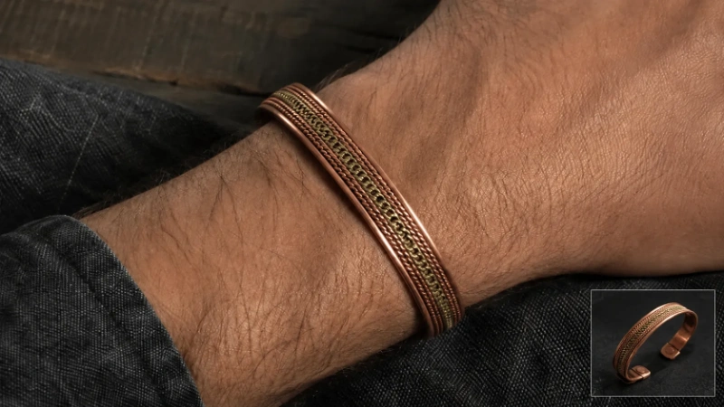Male wrist wearing an antique copper and brass braided cuff bracelet