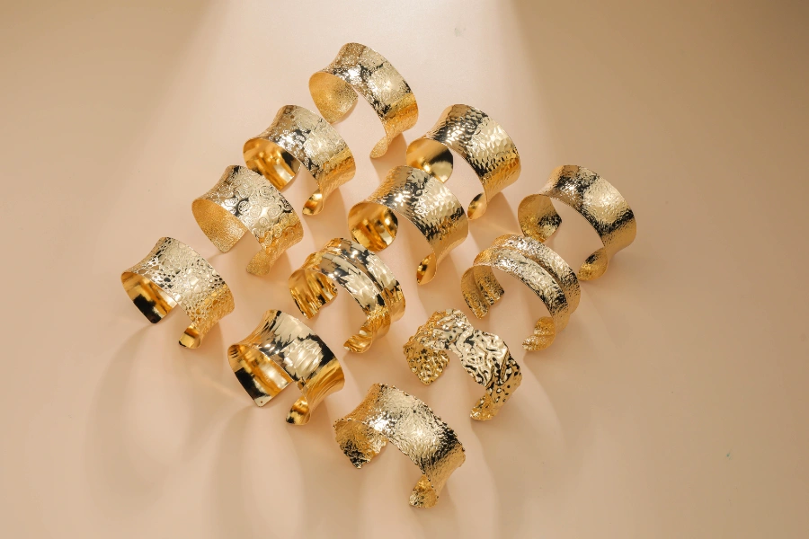 Custom brass cuff bracelet collection featuring hammered, textured, and engraved gold-tone finishes