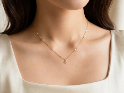 Model wearing a custom gold-tone brass cross necklace developed by an OEM brass necklace manufacturer