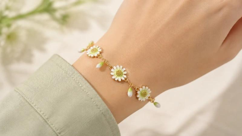 Female wrist wearing a white daisy enamel brass charm bracelet
