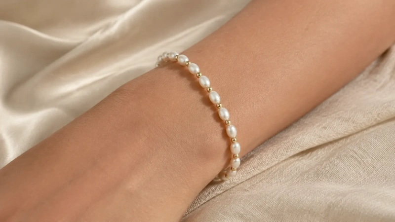 Female wrist wearing a freshwater pearl bracelet with gold brass spacer beads