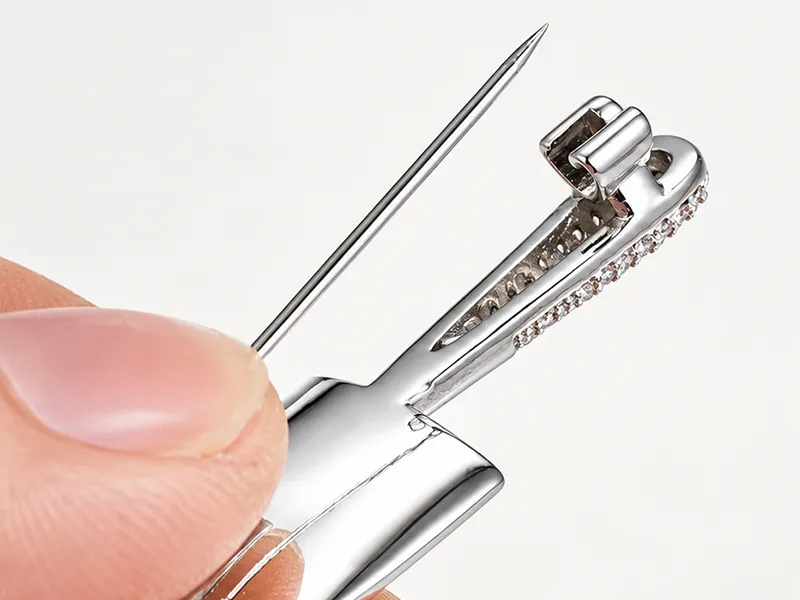 Close-up of a brooch pin back clasp structure showing the needle, hinge and locking mechanism for custom brooch manufacturing.