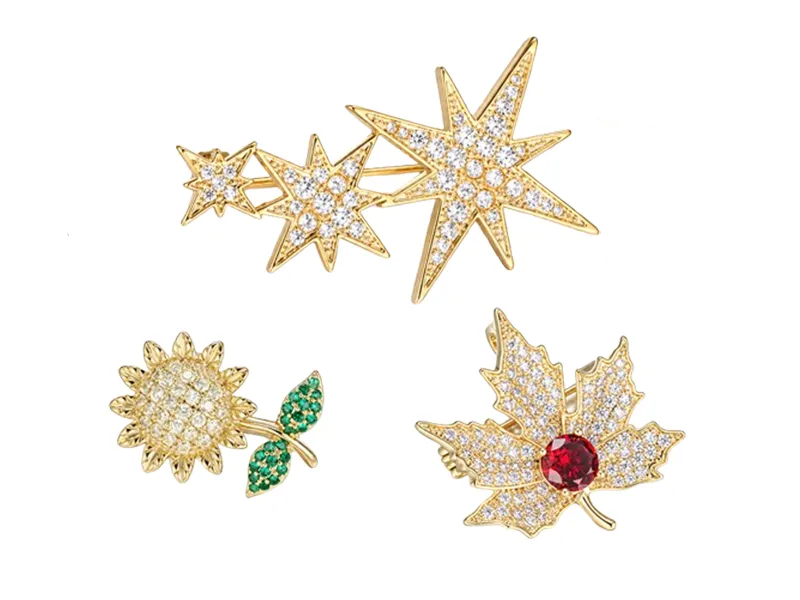 Custom brass brooch manufacturer showing leaf brooches in silver, gold and rose gold finishes.