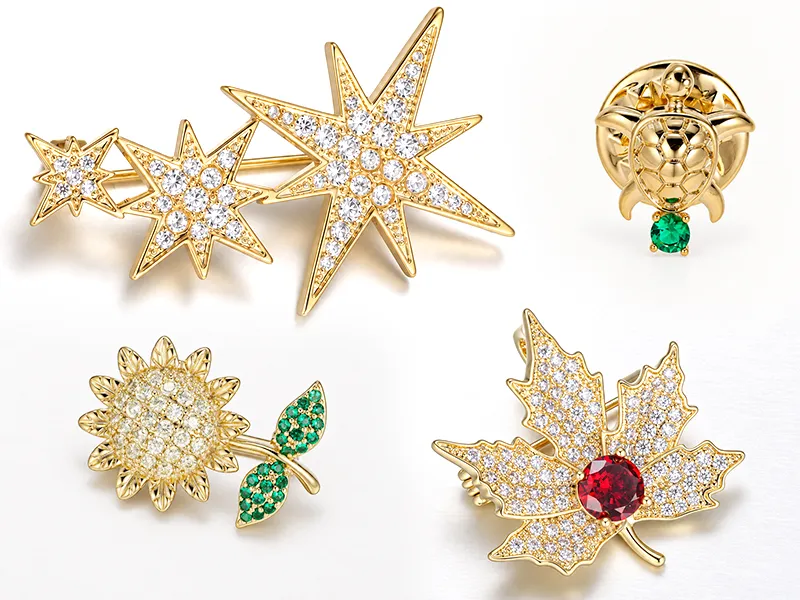 Custom brass brooch manufacturer showing leaf brooches in silver, gold and rose gold finishes.