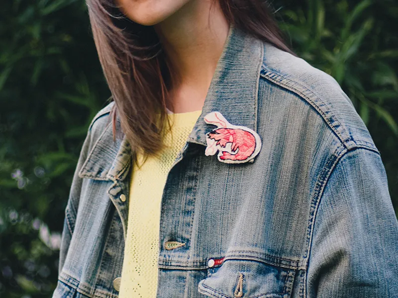 Custom brooch displayed on a denim jacket, showing decorative brooch applications for jackets, coats and fashion collections.