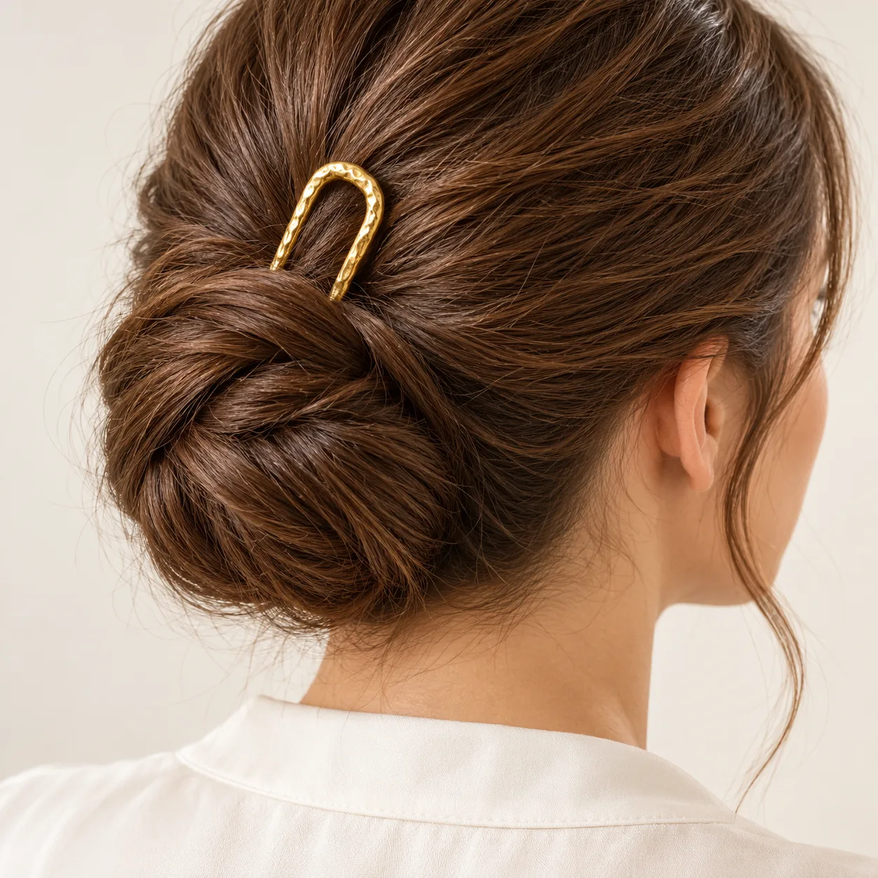 18K gold-plated U-shaped two-prong hair fork with a hammered texture and rounded tips on a clean white background.
