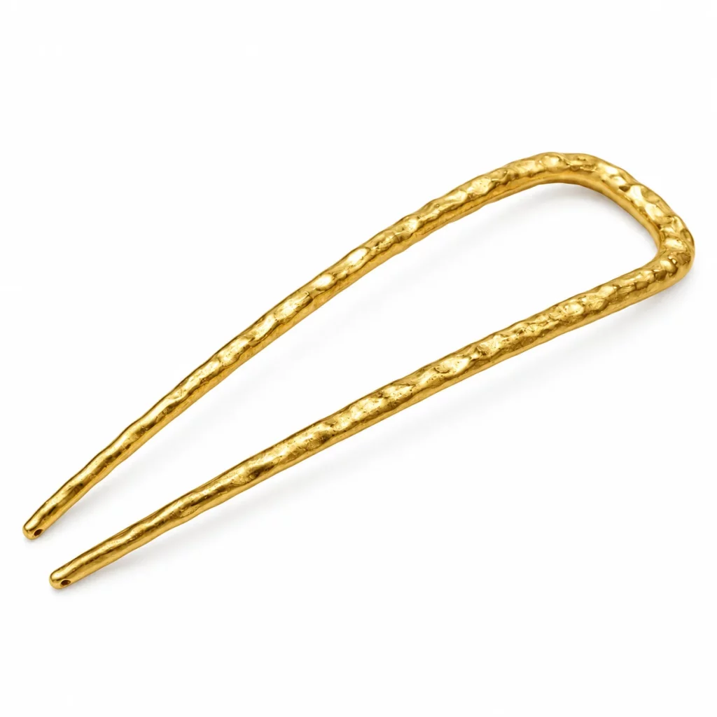 18K gold-plated U-shaped two-prong hair fork with a hammered texture and rounded tips on a clean white background.