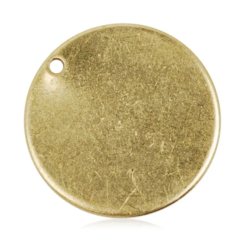Round unplated brass pendant blank with a natural matte finish, visible surface scratches, and a small hanging hole.