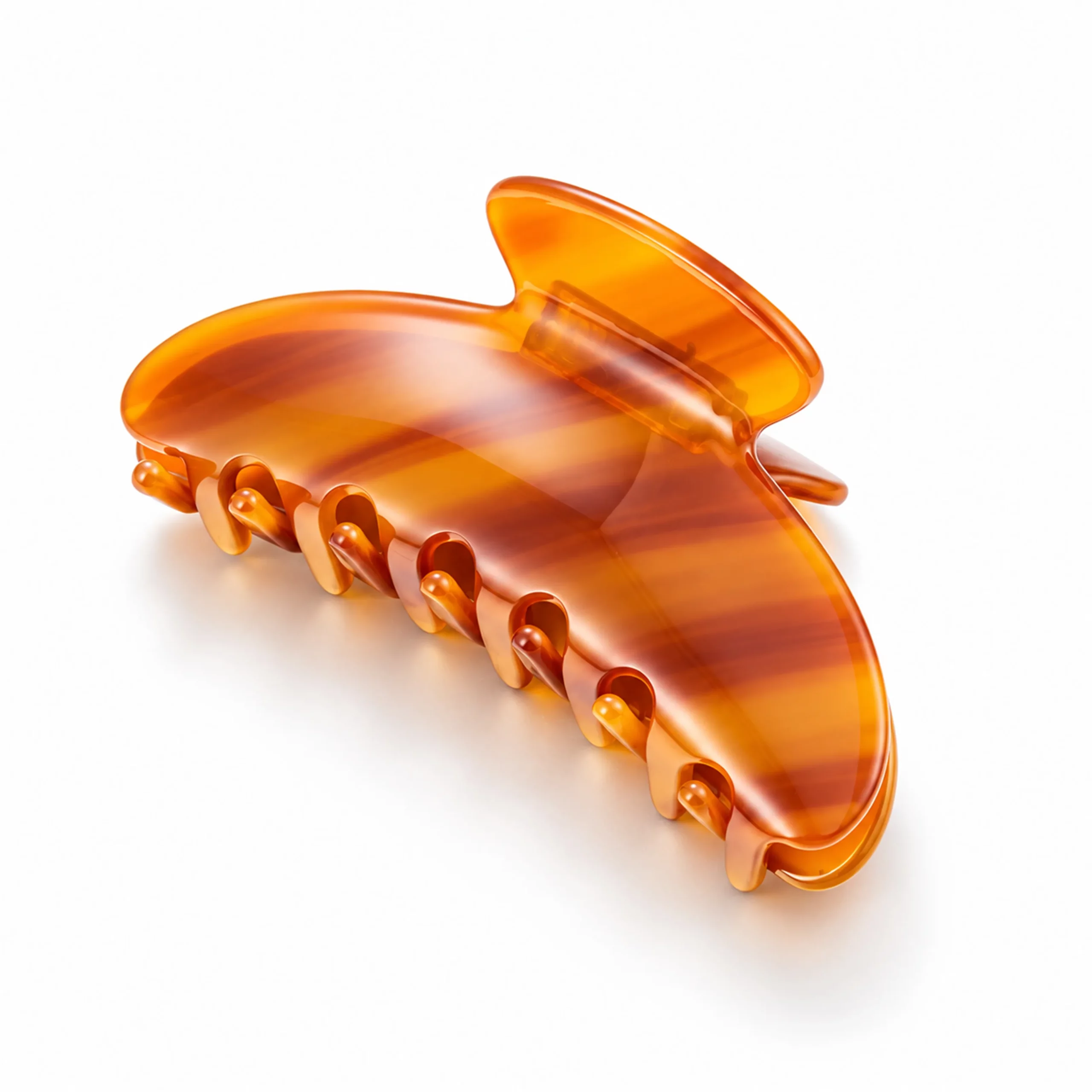 Amber orange cellulose acetate hair claw clip with translucent striped pattern and polished finish.