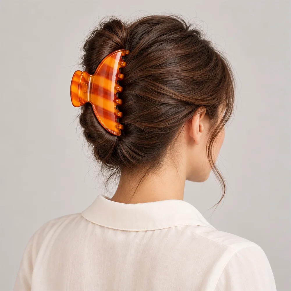 Amber orange cellulose acetate hair claw clip worn with a French twist updo hairstyle.