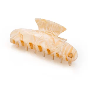 Cream marble cellulose acetate hair claw clip with a polished finish and decorative metal logo detail.