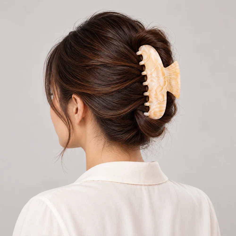 Cream marble cellulose acetate hair claw clip securing an updo hairstyle from the back.