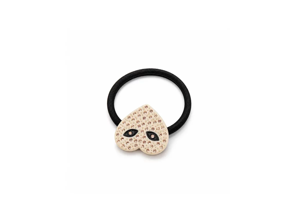 Black elastic hair tie with an ivory heart-shaped charm decorated with crystal accents and black eye motifs.