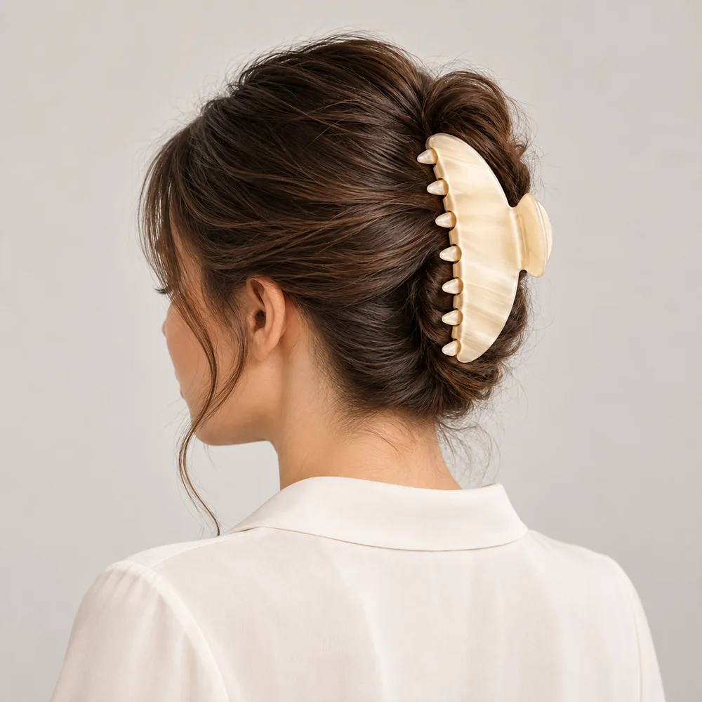 Ivory cellulose acetate hair claw clip worn on a neatly styled updo hairstyle.