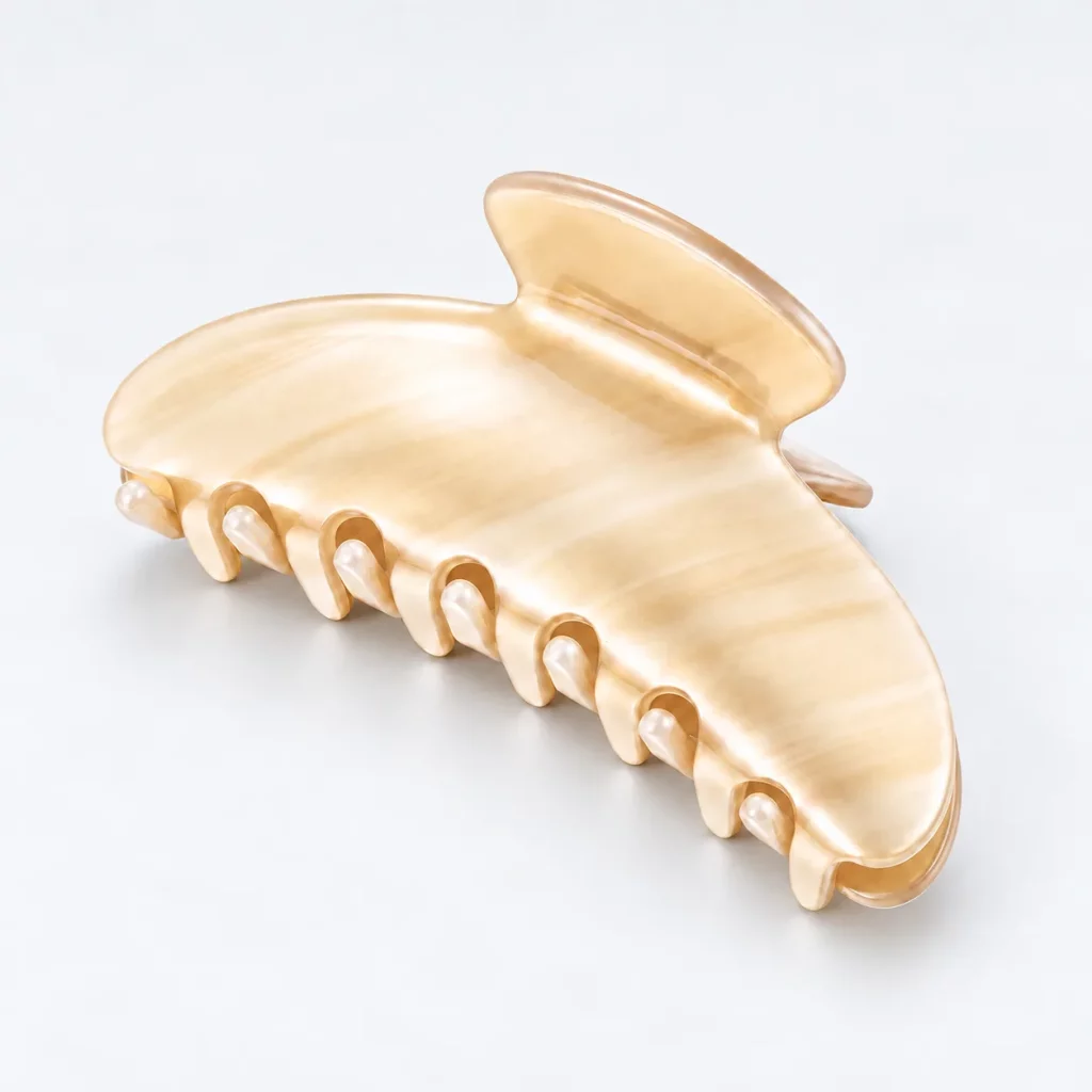 Ivory striped cellulose acetate hair claw clip with a polished marbled finish on a light background.